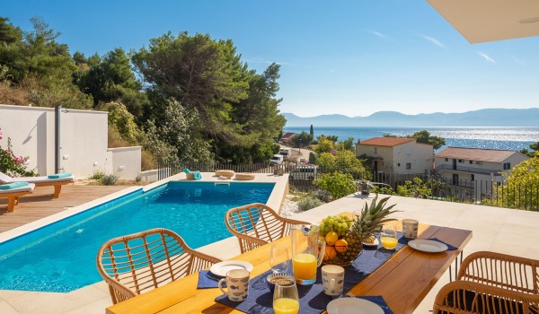 Outdoor dining area near pool of holiday luxury villa Azul in Makarska with sea view.
