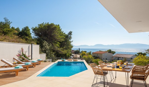 Outdoor dining area near pool of holiday luxury villa Azul in Makarska with sea view.