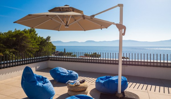 Sunny terrace with outdoor furniture and parasol in Makarska Luxury Villa with private pool and sea view.
