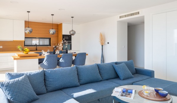 Living room with cozy blue couch and table in modern luxury villla Makarska for vacation and rent.