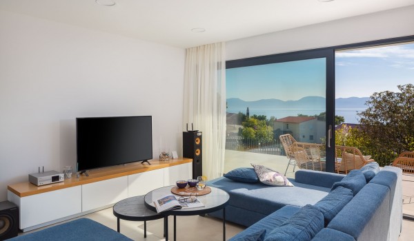 Living room with cozy blue couch and table in modern luxury villla Makarska for vacation and rent.