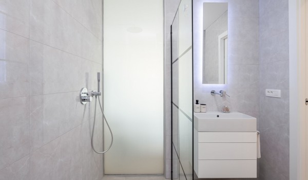 En suite white bathroom with walk-in shower in Makarska luxury modern villa by the sea with pool.