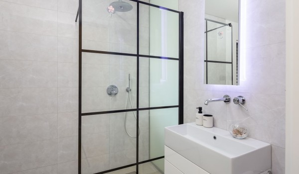En suite white bathroom with walk-in shower in Makarska luxury modern villa by the sea with pool.