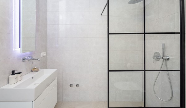 En suite white bathroom with walk-in shower in Makarska luxury modern villa by the sea with pool.