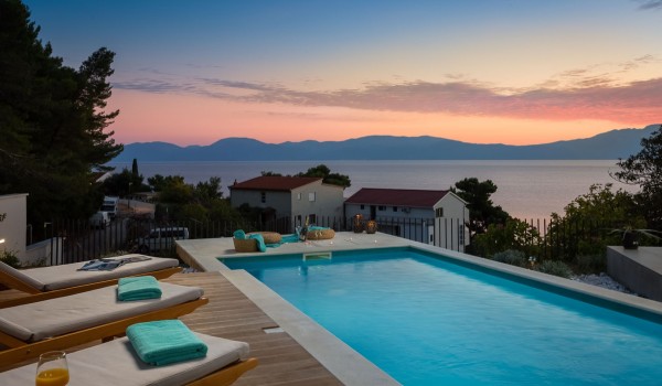 Outdoor pool with deck chairs in Makarska luxury private villa for vacation and rent.