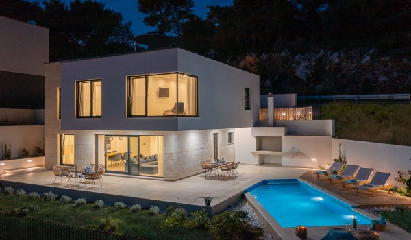 Night picture of property of modern luxury villa Azul in Makarska by the beach with private pool.