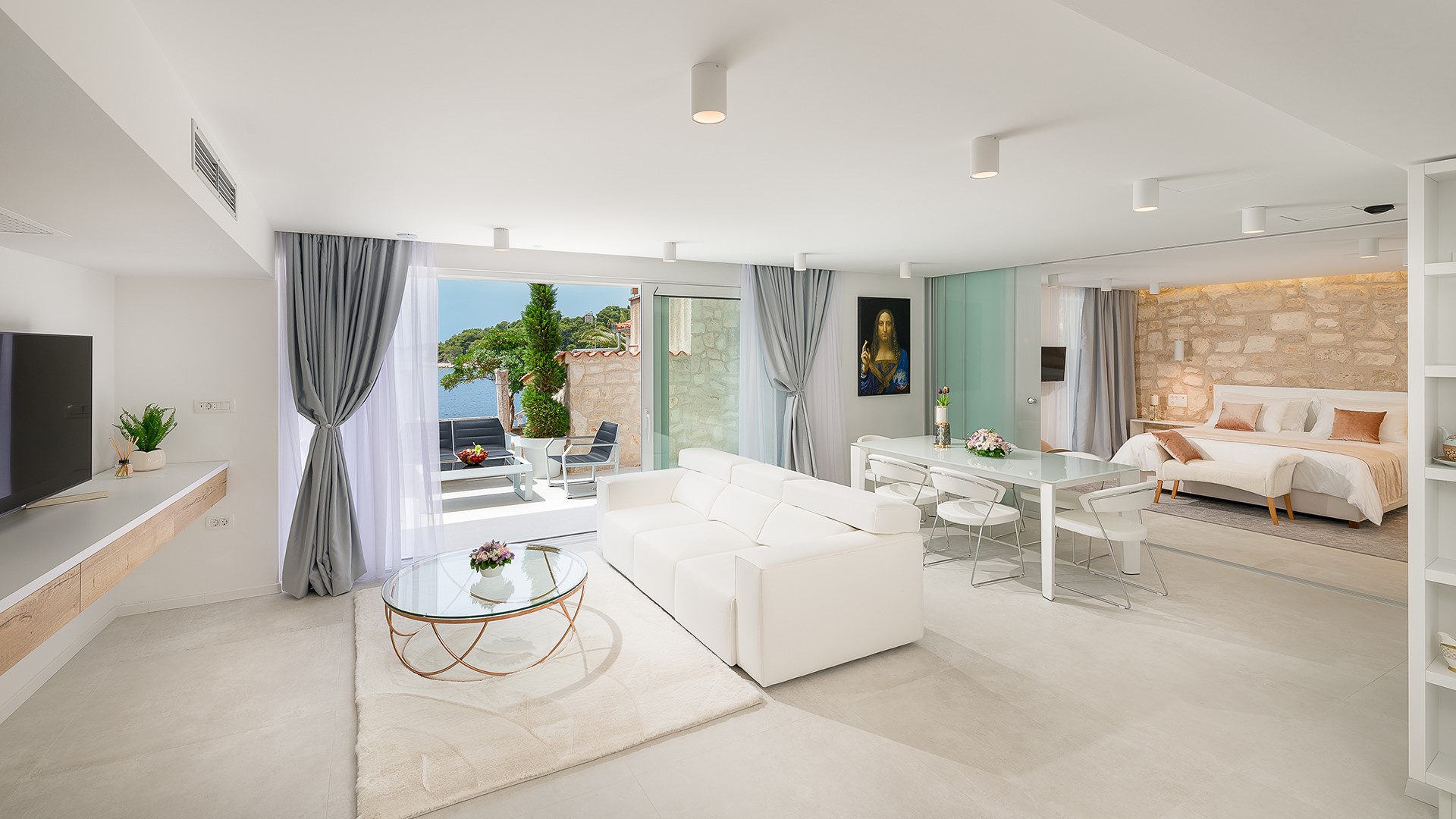 The interior of Croatia luxury Gariful Royal apartment with double-size bed and seating area with SMART TV
