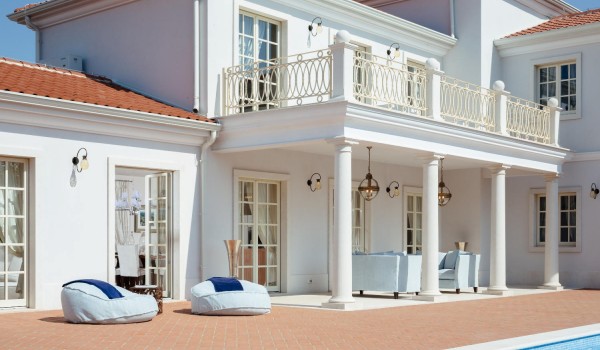 Outdoor terrace with deckchairs for sunbathing and a table and garden armchairs in the luxury villa Lea in Vabriga in Istria