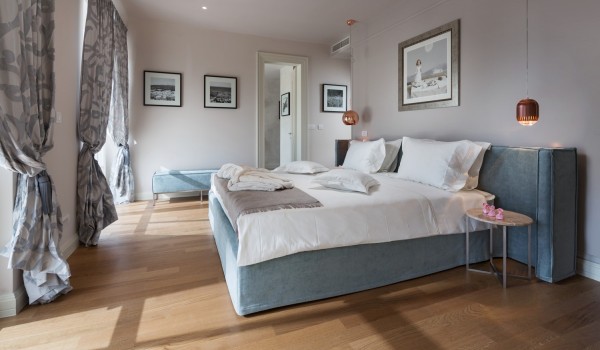 A bedroom with a double bed and a stool in the luxury rental villa Lea in Vabriga in Istria