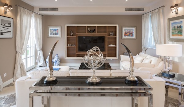 Living room with a glass table with figures and a sofa, armchairs and a large LCD TV in the luxury villa Lea in Vabriga in Istria