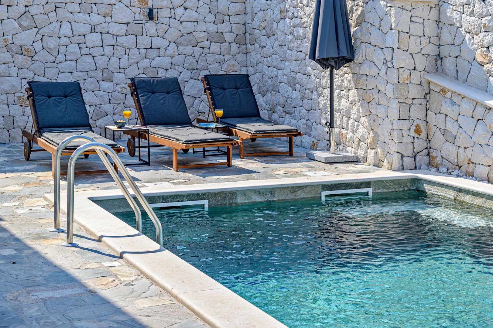 Ein Blick auf die Sonnenliegen am Pool des Kroatien luxuriösen Dream and Live-Villa-Mietobjekts