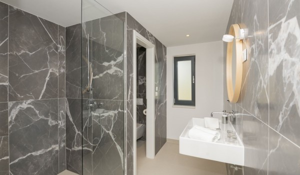 A modern bathroom with a shower cabin, sink and toilet in a luxury villa for rent with a private pool in Brela