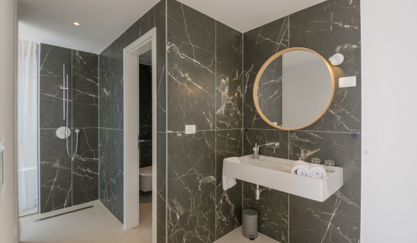 En suite bathroom with shower, sink and mirror in the bedroom in a modern villa for family vacations in Brela