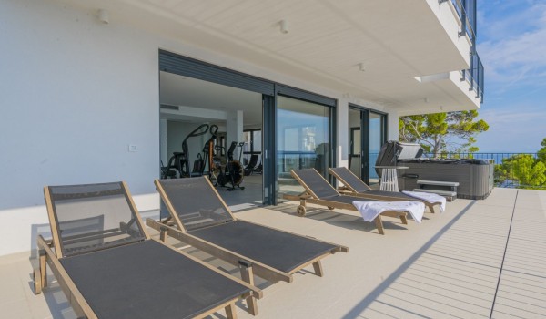 A private gym with access to an outdoor terrace with deckchairs and a jacuzzi in the luxurious holiday villa Glorious Brela in Brela