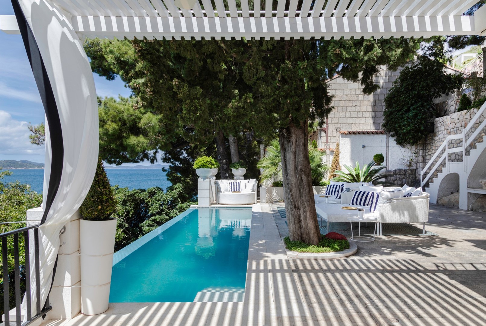 Terrasse der Kroatien luxuriösen Strandvilla mit Esstisch und Sitzbereich am Pool