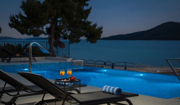 Drinks by the pool on the terrace of the seafront Šibenik villa for vacation with family and friends