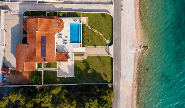Aerial view of a luxury beachfront villa with concierge service and wine cellar