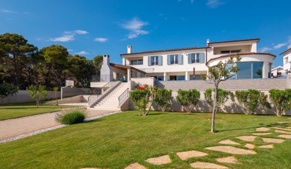 Landscaped garden in front of the Beachfront villa Sea Whisper with concierge service and indoor pool
