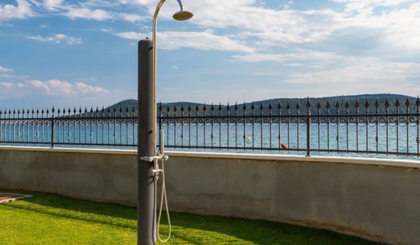 Outdoor shower in the landscaped garden of Beachfront villa Sea Whisper for vacation with family and friends