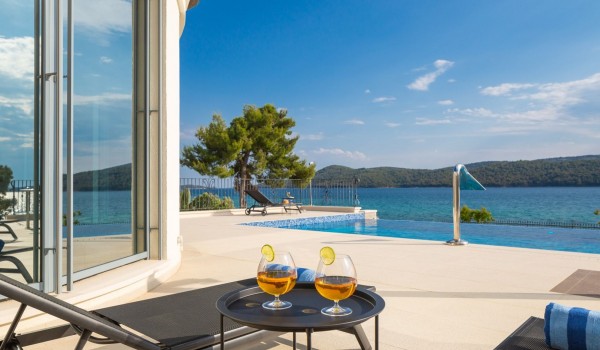 Drinks by the pool on the terrace of the seafront Šibenik villa for vacation with family and friends