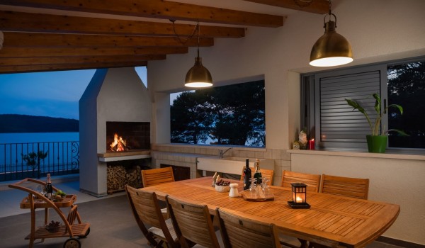 Outdoor dining area with traditional grill in the luxury vacation villa by the sea in Sibenik