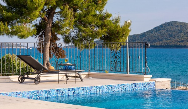 Outdoor infinity pool overlooking the sea in the luxury beachfront villa with concierge service in Sibenik