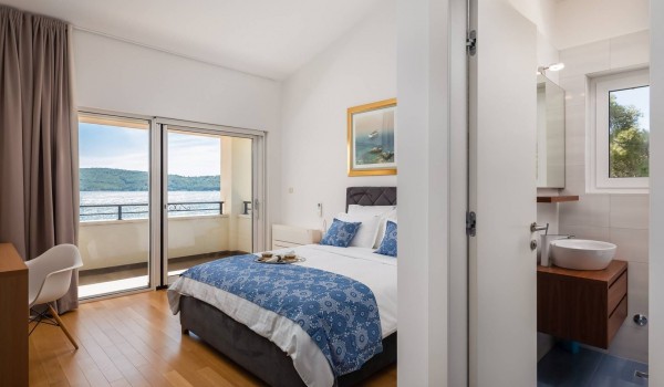 Bedroom with queen size bed and en suite bathroom of the Luxury family vacation villa with concierge service