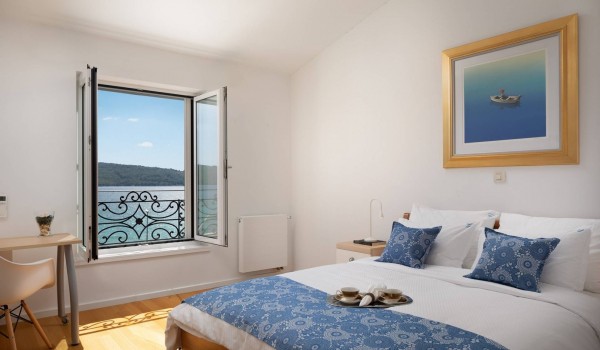 Queen size bed and seating area in a bedroom with sea view of the luxury vacation villa in Sibenik with private parking and wifi