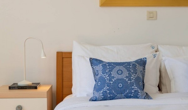 Queen size bed in a bedroom of a luxury seafront villa in Sibenik with gym and sauna