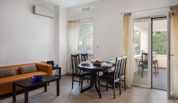 Dining table and sofa in a living room with private terrace of the luxury vacation villa at the beach in Sibenik