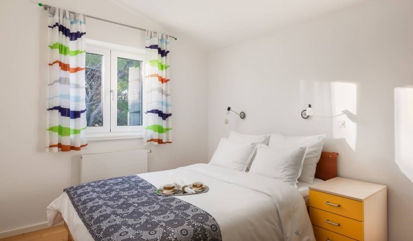 Queen size bed in a bedroom of a luxury Sibenik villa for family vacation by the sea