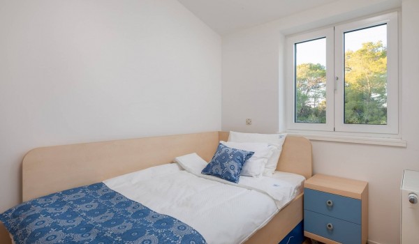Single bed in a bedroom of a Sibenik beachfront villa for family vacation with concierge service and sauna