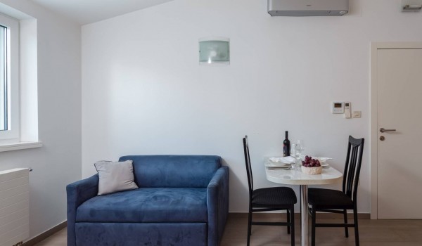 Sofa and dining table for two in a suite of a luxury holiday villa at the beach in SIbenik with indoor heated pool