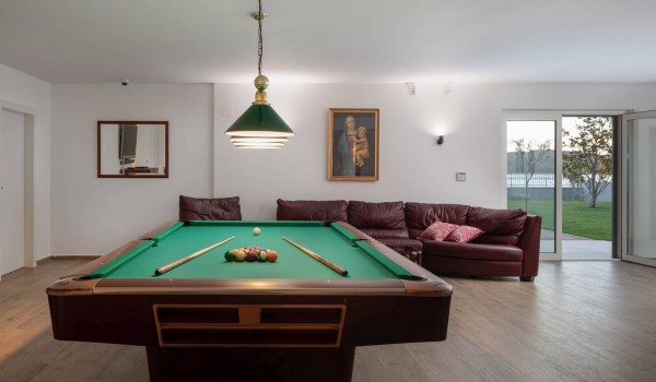 Billiard table and large comfortable sofa in a luxury villa for vacation with friends and family by the sea in Sibenik