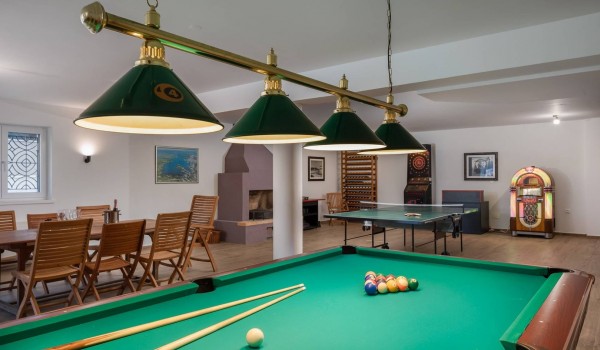 Table tennis, billiard and dining table with indoor grill in the luxury family villa for vacation at the beach in Sibenik