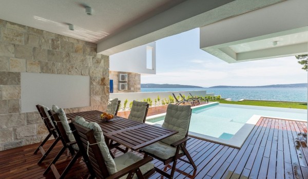 Outdoor dining area by the pool overlooking the sea in the vacation villa in Split with concierge service