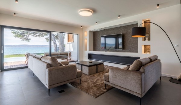 Living room with comfortable sofas and big TV in the modern vacation villa with private pool in Split