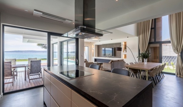 Kitchen island and dining table with direct entrance to the terrace of the vacation villa for family in Split