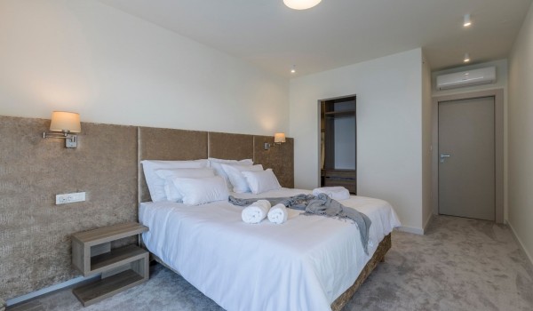 King size bed and ensuite bathroom in the luxury bedroom of the beachfront villa in Kastela  with concierge service