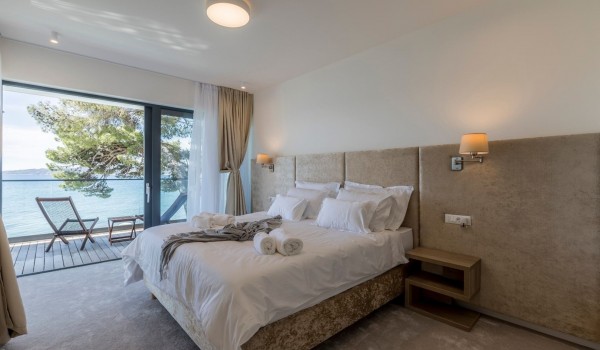 King size bed in the bedroom with private terrace of the beachfront villa for family vacation in Split