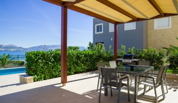 Outdoor dining table on the terrace of a luxury vacation villa with private gym and pool in Ciovo