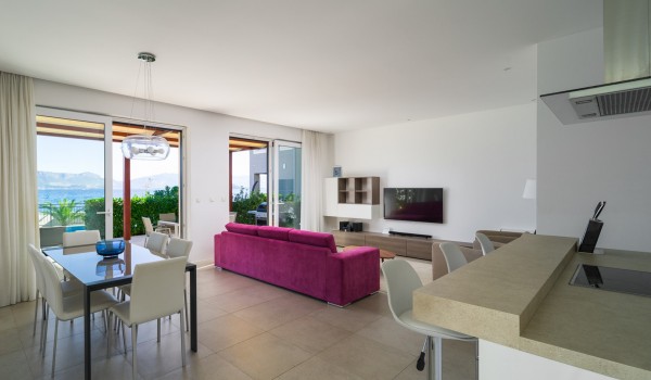 Open space living room with comfortable sofa, dining table and kitchen island in a luxury family villa with private pool and Wi-Fi