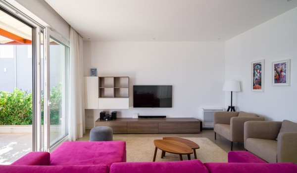 Magenta comfortable sofa and coffee table in a living room of a luxury holiday villa at the beach on Ciovo