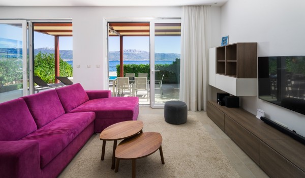 Magenta comfortable sofa and coffee table in a living room of a luxury holiday villa at the beach on Ciovo