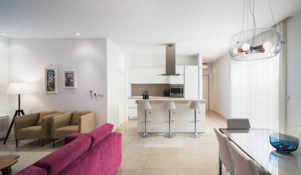 Open space living room with comfortable sofa, dining table and kitchen island in a luxury family villa with private pool and Wi-Fi