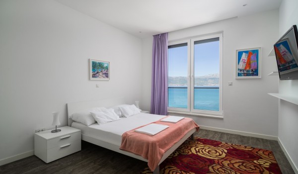 Double bed and Smart TV in a bedroom of a luxury vacation villa with family and friends in Ciovo