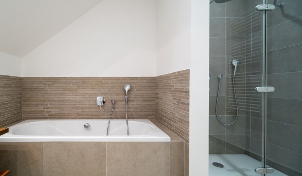 En suite bathroom with bathtub in a bedroom of a luxury beachfront villa for vacation with friends in Ciovo