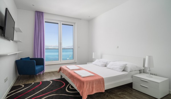 Double bed and Smart TV in a bedroom of a luxury vacation villa with family and friends in Ciovo