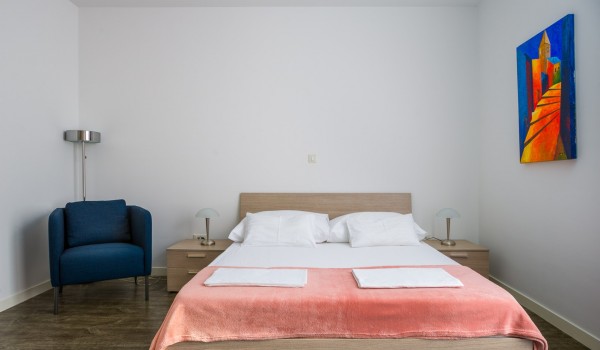 Seating area next to the double bed in a bedroom of a luxury family villa for vacation at the beach in Ciovo