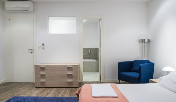 Seating area next to the double bed in a bedroom of a luxury family villa for vacation at the beach in Ciovo